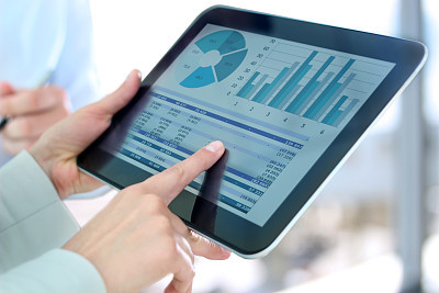 businesswoman showing graphs by finger at the digital tablet