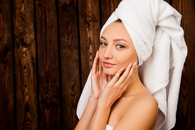 Young pretty girl with towel on head in spa salon
