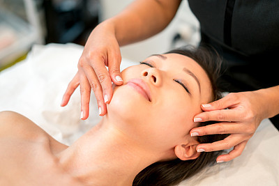 Asian woman getting a face massage at the spa