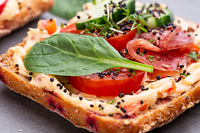 Sandwiches with cream cheese, vegetables and salami.