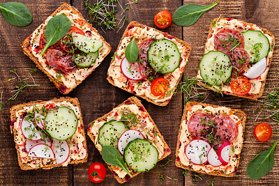 Sandwiches with cream cheese, vegetables and salami.