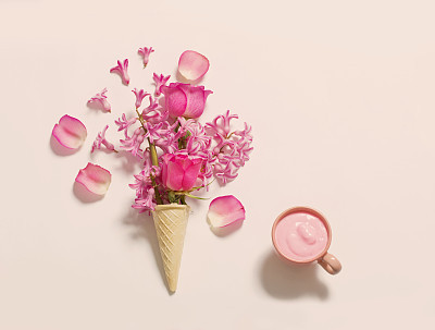 Flowers in a waffle cone with yogurt on white background