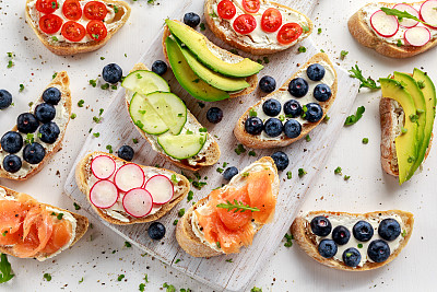 Homemade summer toast with cream cheese Smoked Salmon, Blueberries, Radish, Cucumber, Avocado and cress salad. Fresh healthy concept food.