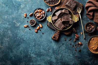 Dark chocolate pieces crushed and cocoa beans, culinary background, top view