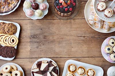 Table with cake, pie, cupcakes, tarts and cakepops. Copy space.