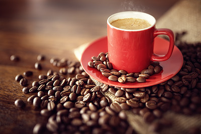 Coffee cup on burlap sack with roasted beans