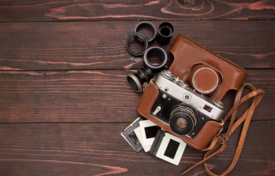 Vintage camera ,slides  and lens ,brown wooden planks.Retro ecuipment .Memories concept.