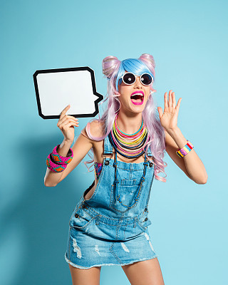 Blue-pink hair girl in funky manga outfit holding speech bubble
