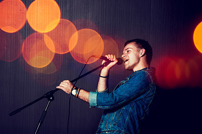 Young Man Singing with Microphone.