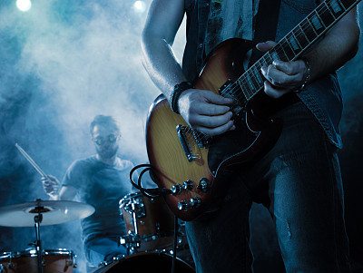 Rock band performs on stage. Guitarist.