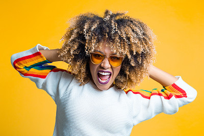 Funky afro young woman against yellow background