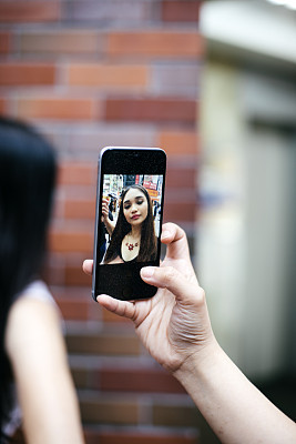 Young woman taking a self portrait photograph, a selfie