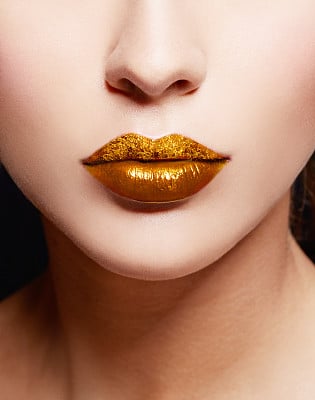 Close up of gold artistic lips. Makeup cosmetic image.