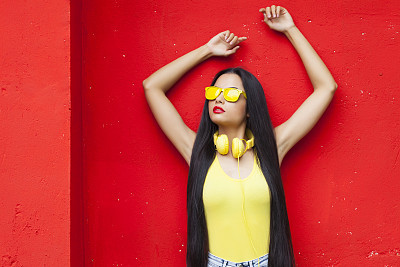 Woman in yellow vest and sunglasses with long hair