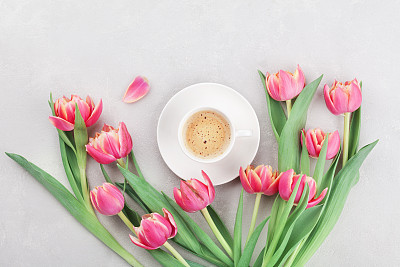Cup of coffee with spring tulip flowers for good morning on Mothers or Womens day. Flat lay.