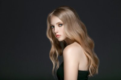 Beautiful Blonde Woman Beauty Model Girl with perfect makeup and hairstyle over black background.