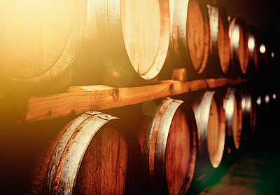 Wine barrels stacked in cellar in mellow golden light