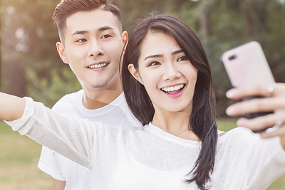 Happy young couple in love taking a selfie on phone