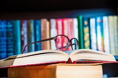 glasses and book on background bookcase