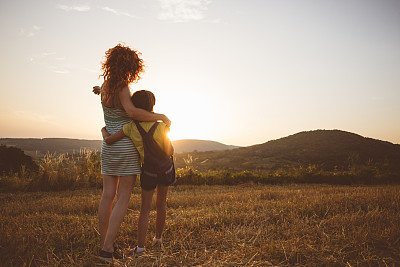 Loving hug of mother and daughter in wheat field
