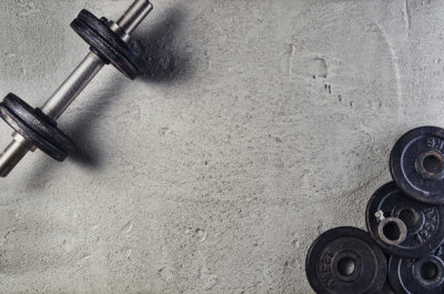 Fitness or bodybuilding background. Dumbbells on gym floor, top view