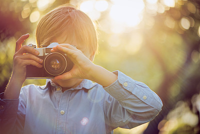 Little boy photographing in park