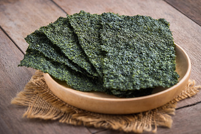 Crispy dried seaweed on wooden plate