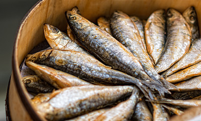dried mackerel on a market at a wooden basket