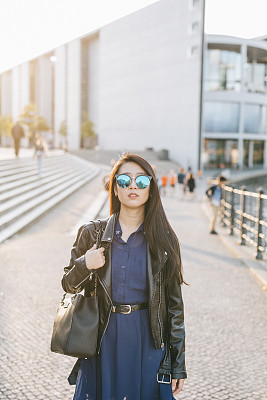 Portrait of young woman walking in the city.