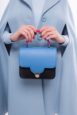 Young woman in jacket holding leather handbag in pink colors