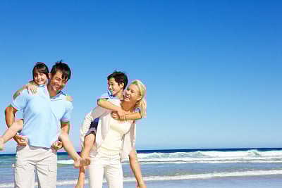 Smiling parents giving kids piggyback rides