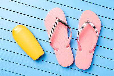 Pink flip flops on blue wooden table