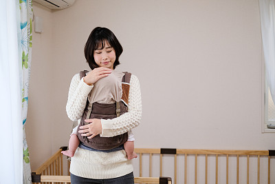 Baby sleeping in arms of mother