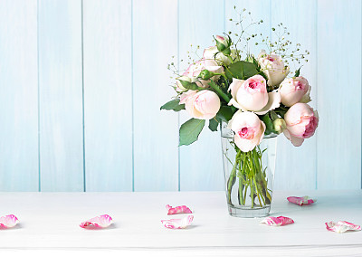 Roses flowers bouquet in vase on table empty background.