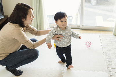 Mother playing with her baby girl at home