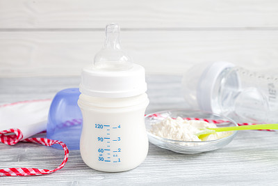 preparation of mixture baby feeding on wooden background