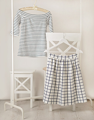 Fashion trend stripes. White striped top and white skirt in cell.