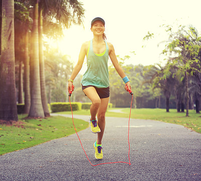 young fitness woman runner tying shoelace on road
