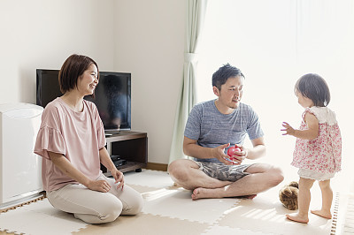 Baby girl playing with family in home