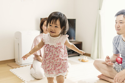 Baby girl playing with family in home