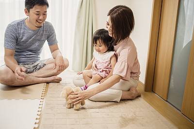 Baby girl playing with family in home