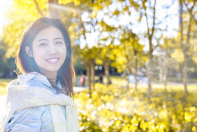 Portrait of Asian fashion young woman under sun flare at park,Shanghai,China