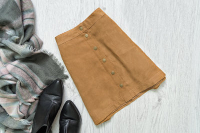 Brown suede skirt, black shoes and scarf. Fashionable concept.