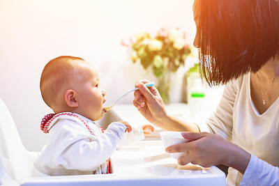 Young mom feeding her kid