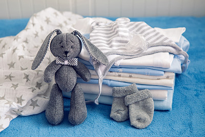 baby clothes with diapers are stacked