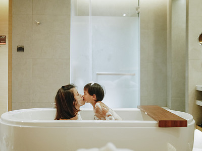 Asian Mother And Baby Son Having Fun At Bath Time Together