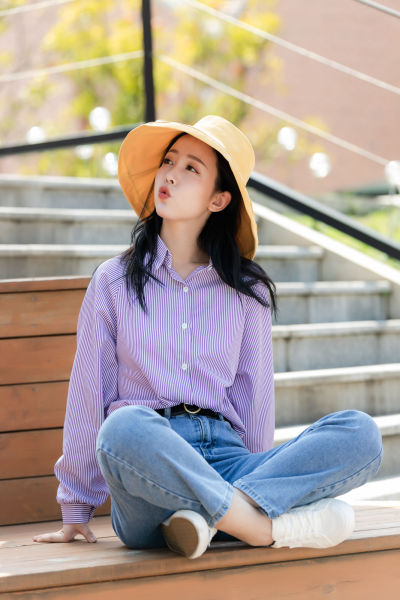 服饰系列实景模特穿着紫色衬衫和蓝色牛仔裤的室外摆拍