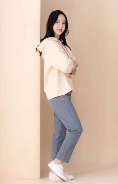 服饰系列实景模特穿着杏色卫衣和灰色长裤的室内摆拍