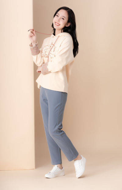 服饰系列实景模特穿着杏色卫衣和灰色长裤的室内摆拍