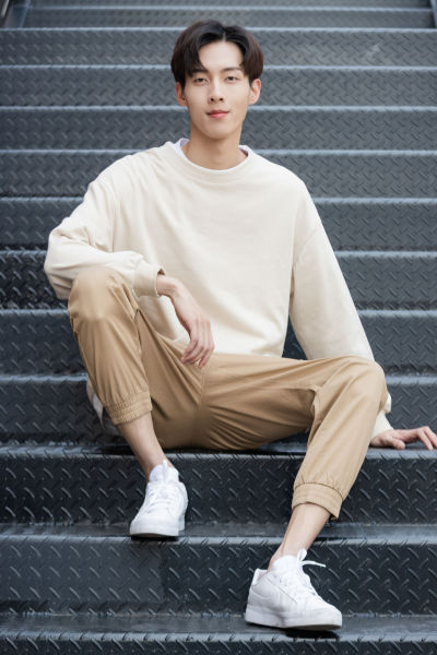 服饰系列实景模特穿着白色卫衣和卡其色长裤的室内摆拍